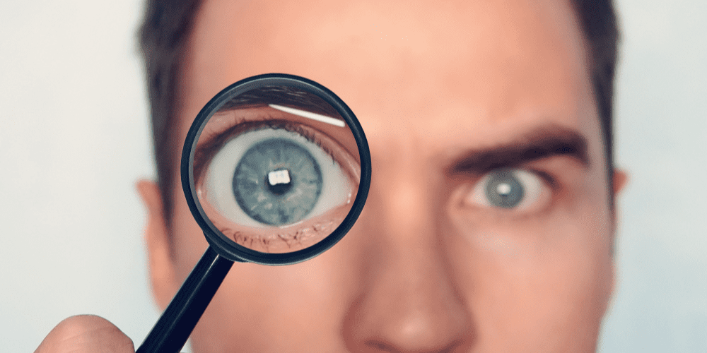 Human face with a magnifying glass over one eye