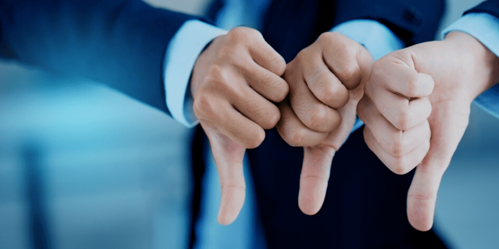 Three hands with thumbs down showing negativity