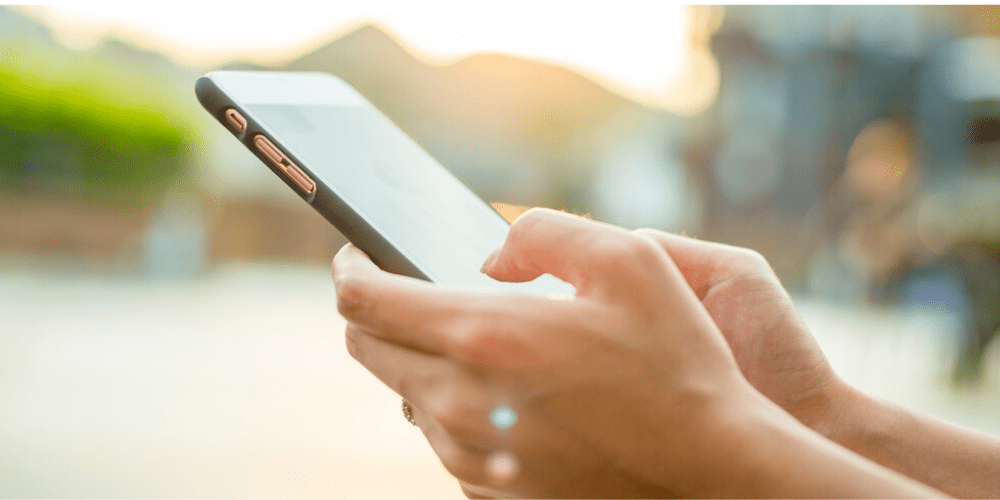 Two hands holding a smartphone showing internet search with responsive and dynamic ads