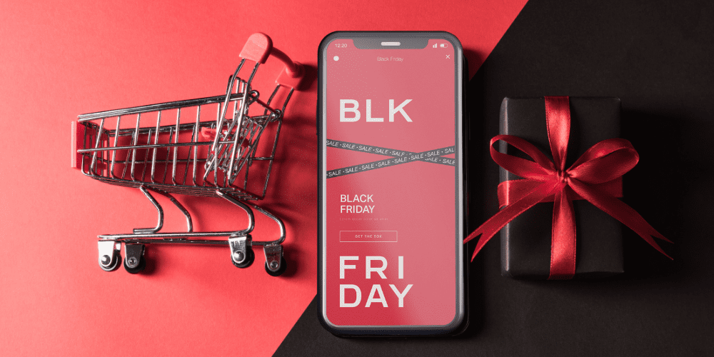 Black Friday e-Commerce Marketing Strategies, phone with black friday written on it, shopping cart and gift image
