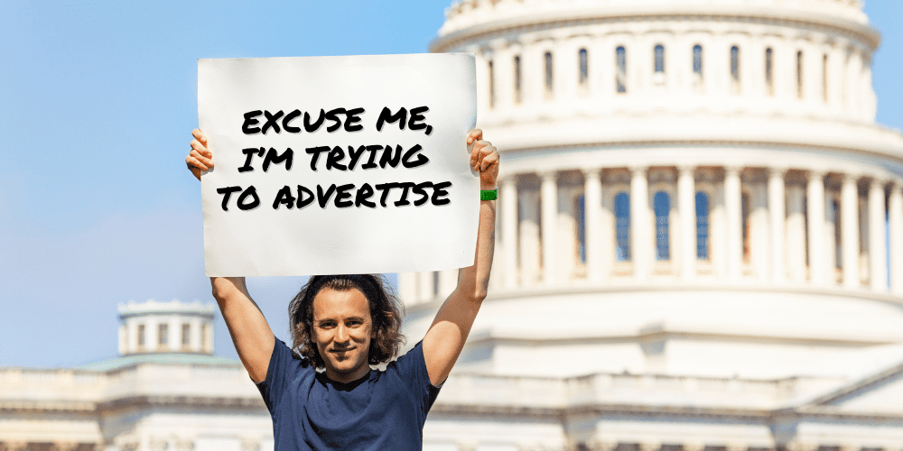 Political Season Advertising Comprehensive Guide to Effective Media Buying, a man in front of congress building holding a sign that says, "Excuse me, I'm trying to advertise."