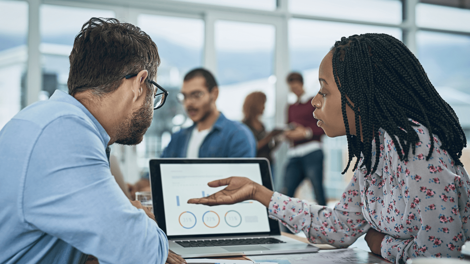How Colling Media Uses Data-Driven Marketing Strategies to Maximize ROI, two business people in office reviewing digital dashboard and metrics