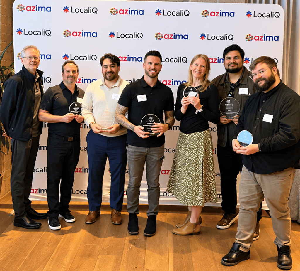 Colling Media staff holding 7 AZIMA 2026 awards at the awards ceremony in front of azima backdrop.